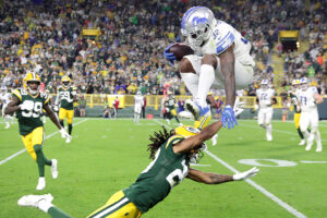 Detroit Lions running back D’Andre Swift (32) jumps over Green Bay Packers cornerback Kevin King (20) during the second half at Lambeau Field in Green Bay, Wis., Monday, Sept. 20, 2021.