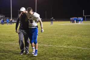 Riverside assistant coach Will Wragge helps Michael Bernt off the field Wednesday, Oct. 31, 2018, after the Charges lost 50-22 to the Kenesaw Blue Devils.