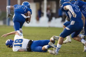 Riverside’s Michael Bern (18) misses the tackle of Kenesaw running back John Schuster (34) and is trampled by a pack of Blue Devils on Wednesday, Oct. 31, 2018, during the second round of Class D-2 playoffs in Kenesaw.